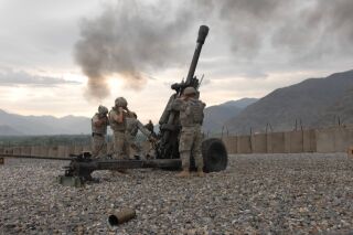 Soldiers fire an M119 Howitzer